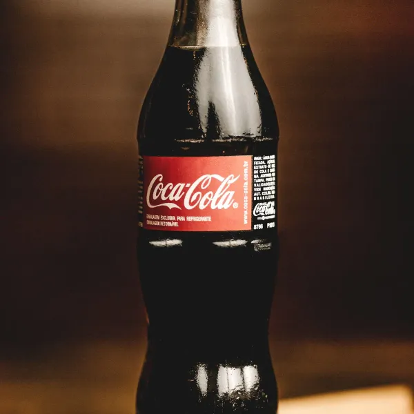 Botella de refresco sobre mesa de madera